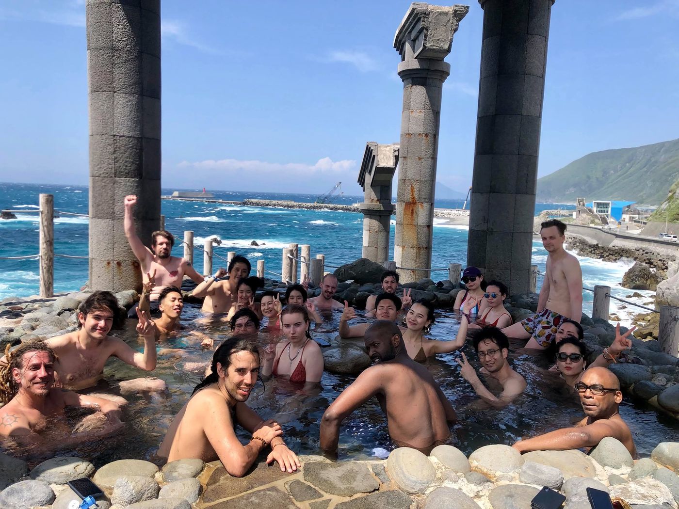 The family soaking in a seaside rock onsen